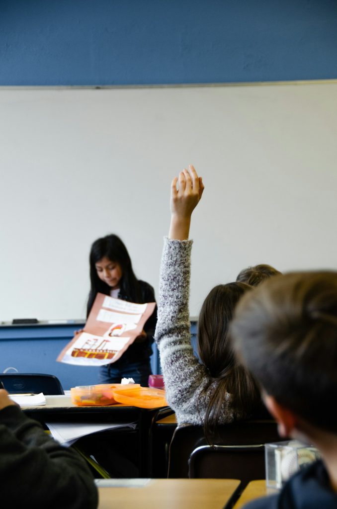 woman-in-gray-sweater-sitting-beside-woman-in-gray-sweater-ntur2-qkpg0 Girl raises her hand in class